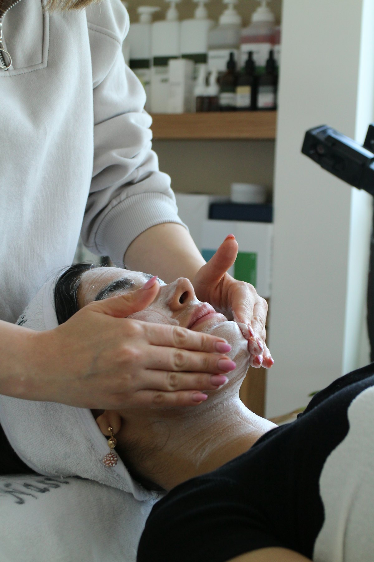Therapist's hands working over a client's face during a treatment