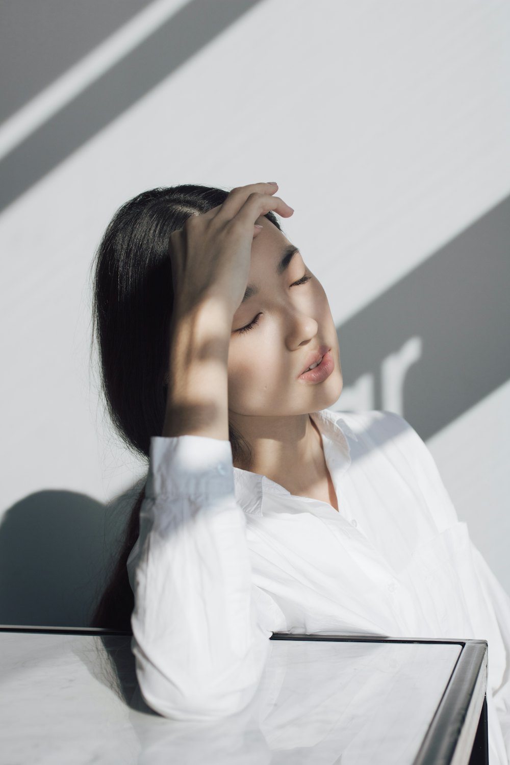 Woman resting her hand on her forehead in soft daylight